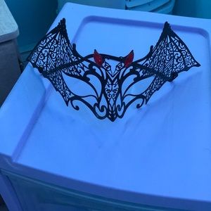 Halloween bat mask black and metal has red gems on it